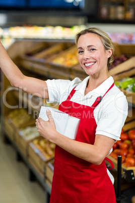 Smiling seller holding white plastic bag