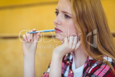 Unsure student holding pen during class