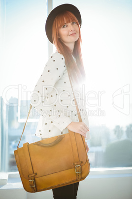 Portrait of a smiling hipster woman with a bag