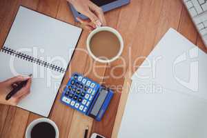 Cropped image of woman writing on notepad