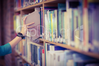 Students hand with smartwatch picking book from bookshelf