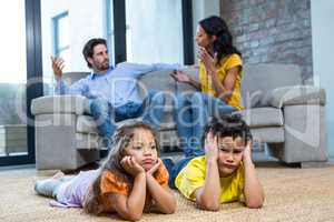 Children laying on the carpet in living room