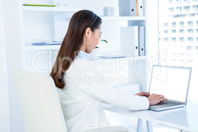 Businesswoman in white shirt using laptop