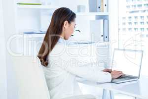 Businesswoman in white shirt using laptop