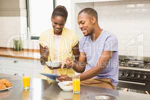 Young couple using tablet at breakfast