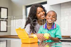 Smiling mother preparing sons school lunch