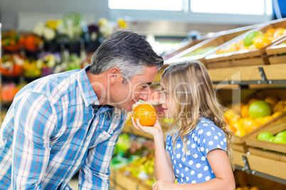 Cute girl holding an orange to her father