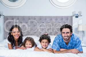 Smiling family laying on the bed