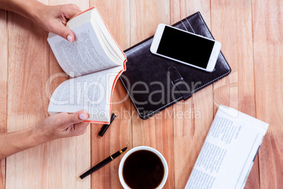 Overhead of feminine hands holding a book