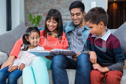Happy young family reading a book together