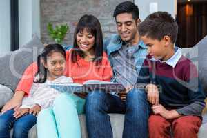 Happy young family reading a book together