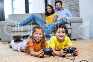 Children playing video games on the carpet in living room