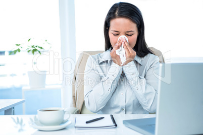 Businesswoman blowing her nose