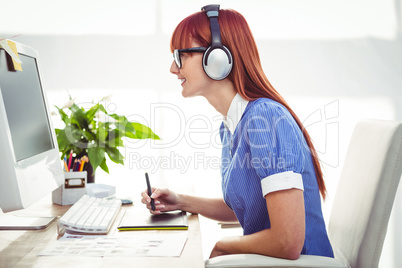 Attractive hipster woman with headset using graphics tablet