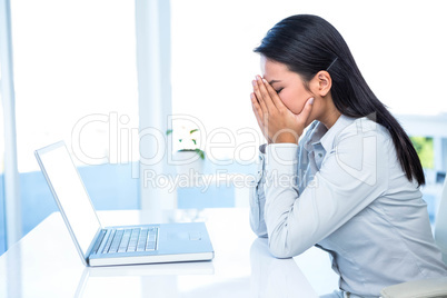 Worried businesswoman covering face