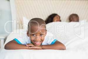 Smiling son lying on bed