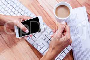 Businesswoman holding hot beverage and smartphone