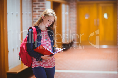 Pretty student with backpack holding notebook