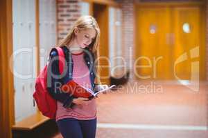 Pretty student with backpack holding notebook