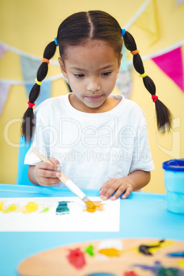 Focused girl using a paintbrush