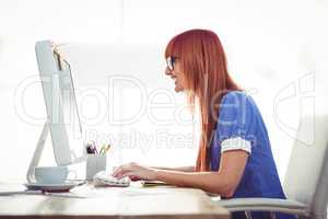 Smiling hipster woman typing on keyboard