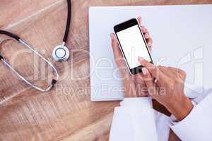 Doctor using smartphone on wooden desk