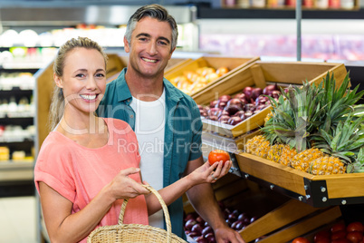 Happy couple holding tomatoes