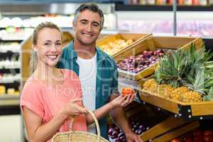 Happy couple holding tomatoes