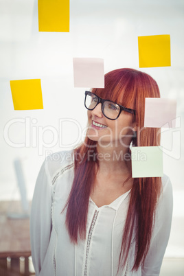 Attractive hipster woman looking at sticky notes