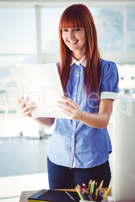 Smiling hipster woman holding document