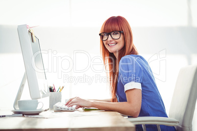 Smiling hipster woman typing on keyboard