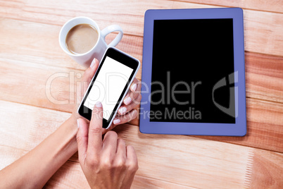 Businesswoman using her smartphone on desk