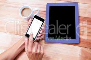 Businesswoman using her smartphone on desk