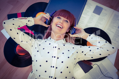 Smiling hipster woman with headphones listening to music