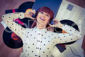 Smiling hipster woman with headphones listening to music