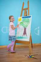 Smiling girl beside her picture