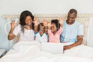 Happy family shopping online with laptop