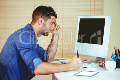 Handsome hipster working at desk