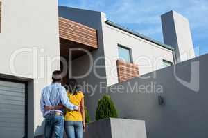 Happy couple standing and looking at the new house