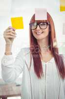 Attractive hipster woman looking at sticky notes