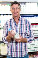 Portrait of a man holding milk bottle