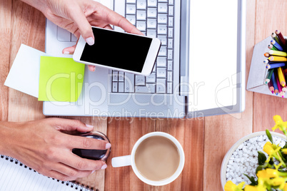 Overhead of feminine hands using smartphone and mouse