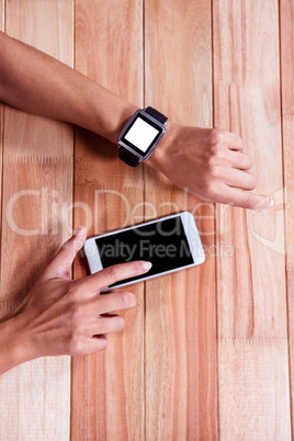 Woman with smartwatch using smartphone