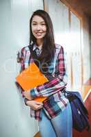 Cheerful student standing next the locker