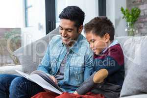 Happy father reading book with his son