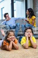 Children laying on the carpet in living room