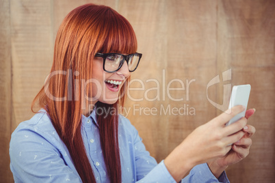 Smiling hipster woman texting on her smartphone