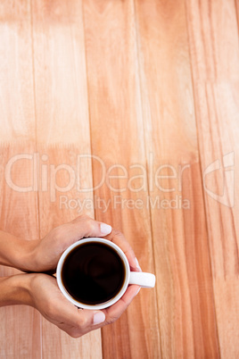 Womans hands holding cup of coffee