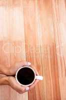 Womans hands holding cup of coffee