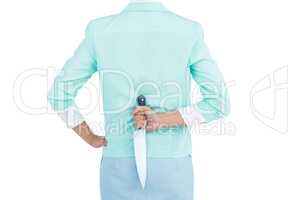 Rear view of businesswoman hiding knife in her back